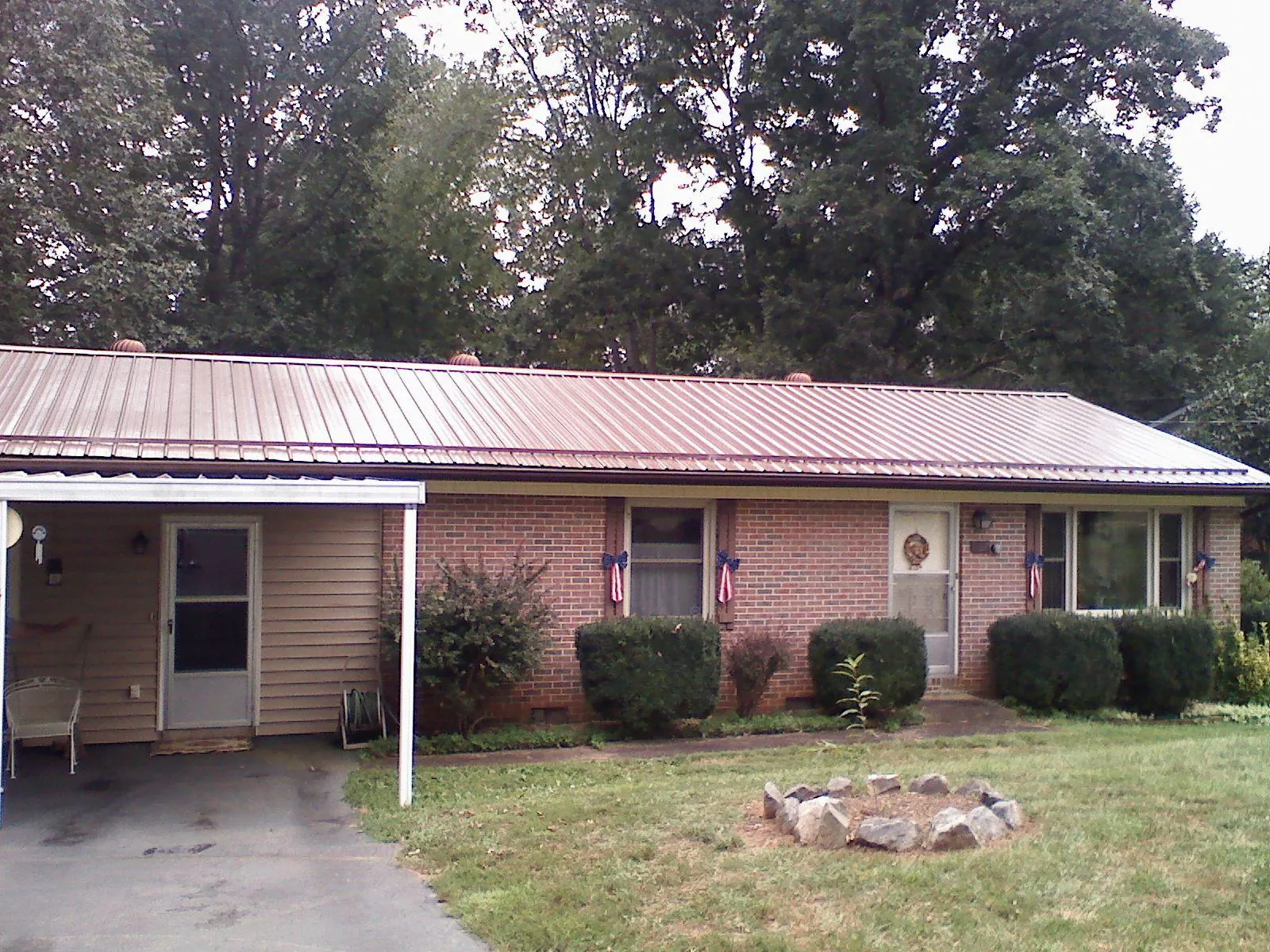Bronze metal roof and carport on a brick ranch home — Roof Repair work by our crew in Madison